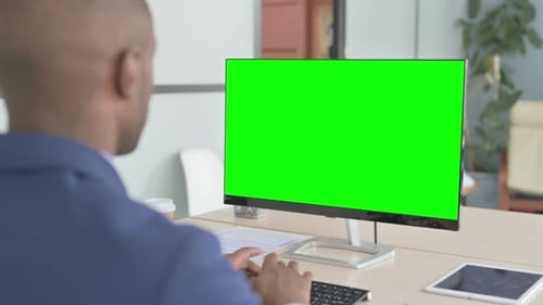 Young African Businessman Using Desktop with Green Screen
