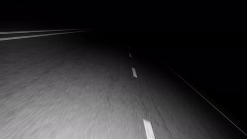 Asphaltstraße, die nachts in die Dunkelheit führt