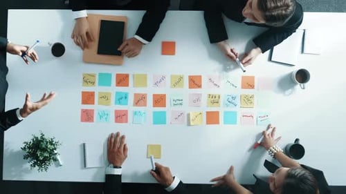 Brainstorming Session: Business Team Writing Ideas on Sticky Notes