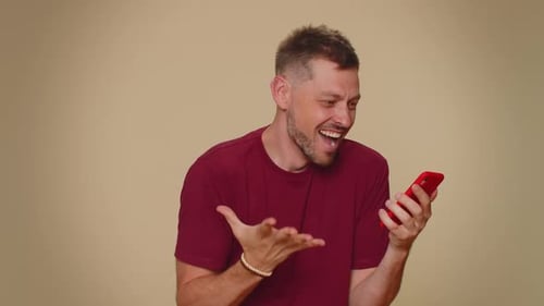 Man Cheering Good News on Mobile Phone