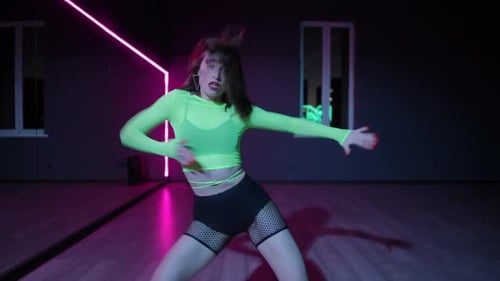Live Camera Dancehall Performed By a Beautiful Young Girl in a Bright Stage Costume in a Dark