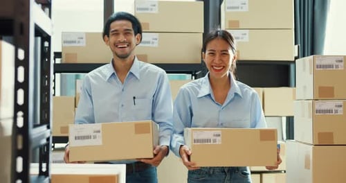 Asian business success partnership man and woman wear uniform shirt carry cardboard box smiling look