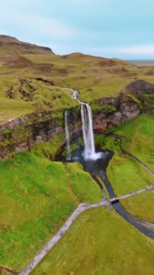 Aerial View of Majestic Waterfall and Green Landscape