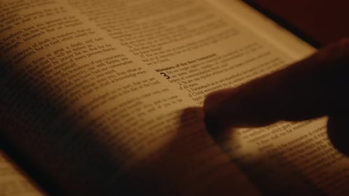 Open Bible with finger Resting on the Page