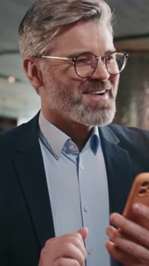 Smiling Man Browsing and Celebrating Good News on Smartphone