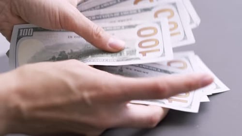 Nahaufnahme der Hände einer Frau beim Zählen von Bargeld, 1000 amerikanischen Dollar, Banknoten, Einkommensgewinner und Geschäft
