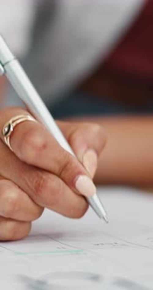 Woman writes on a calendar or planner close-up