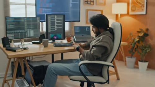 Männlicher Softwareingenieur tippt auf dem Smartphone, während er von zu Hause aus arbeitet