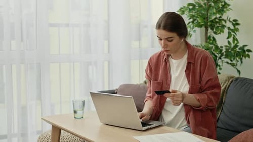 Young Woman Shops Online Using Credit Card
