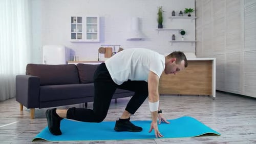 Man Doing Lunges on Yoga Mat Indoors
