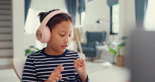 Young Girl Learning Online at Home with Headphones