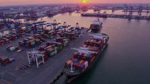 A Breathtaking Aerial View Capturing Cargo Ships at Sunset in the Bustling Harbor Port