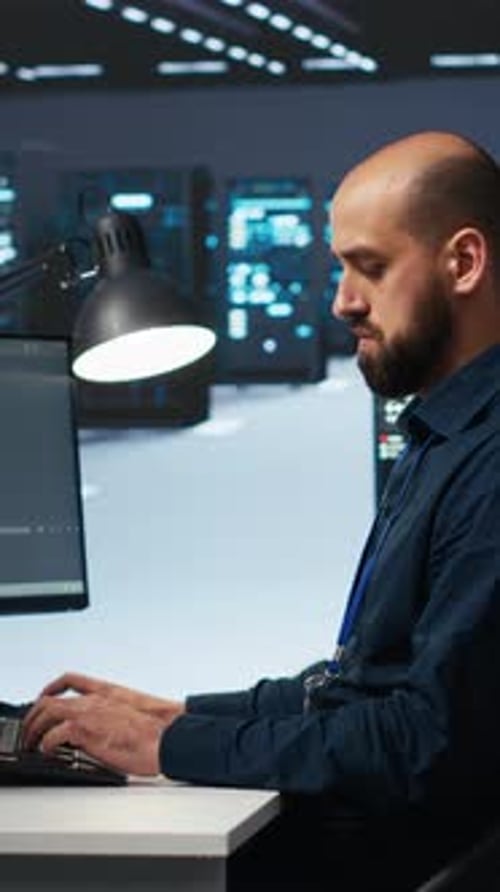 Vertical Video Technician Typing Code on Computer to Mend Data Center Racks