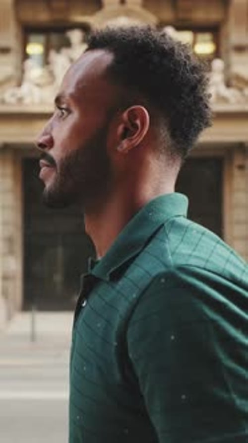 Profile of young man walking down the street in the old town background
