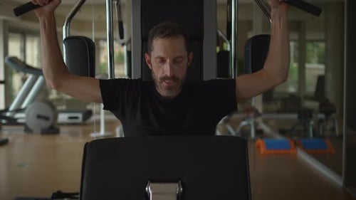 Man Working Out in a Contemporary Gym Setting Focused on Physical Fitness and Health