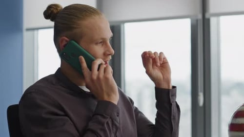 Serious manager talking smartphone in modern office interior close up portrait