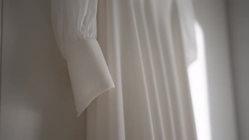 Elegant close up of a white dress sleeve showcasing delicate fabric texture.