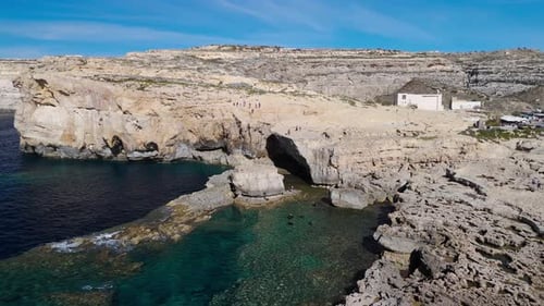 Drone aerial view over Dwejra Hole in Gozo, Malta, showing divers in clear waters, cinematic 60FPS