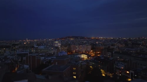 Aerial Evening Footage of Metropolis Fly Above Buildings in City and Revealing Square Illuminated By