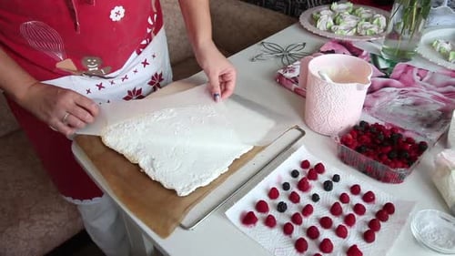 A Woman Removes Food Paper From A Baked Meringue Biscuit. Prepares Meringue Roll With Mascarpone Cre
