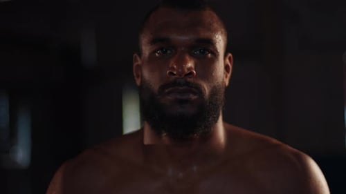 MMA fighter. Portrait of the man fighter standing in the dark gym