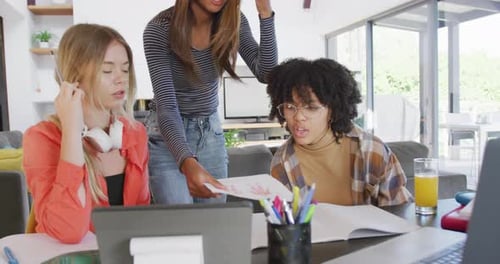 Three Young Adults Studying Together Indoors