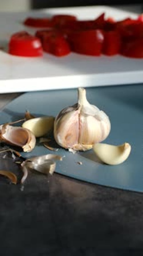 Fresh Garlic and Chopped Red Peppers on a Cutting Board