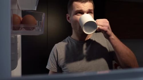 Sleepy Man Drinking From Mug At Night