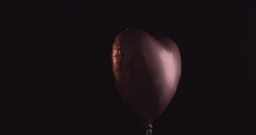 Heart Shaped Balloon Floating on Dark Background