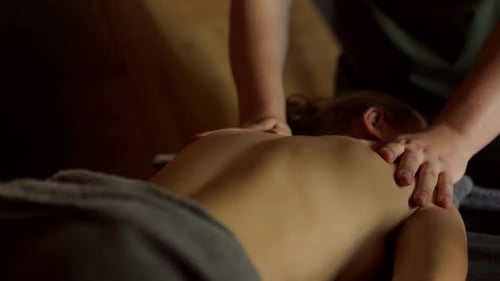 Woman Receives Back Massage in Dark Room