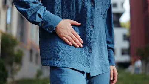Woman Experiencing Abdominal Pain Outdoors