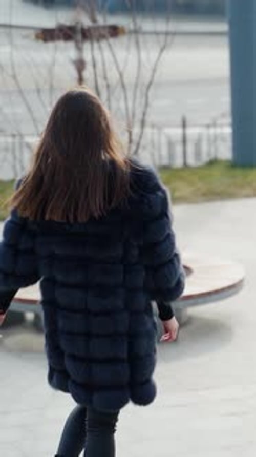 Chica con abrigo de invierno en la ciudad.