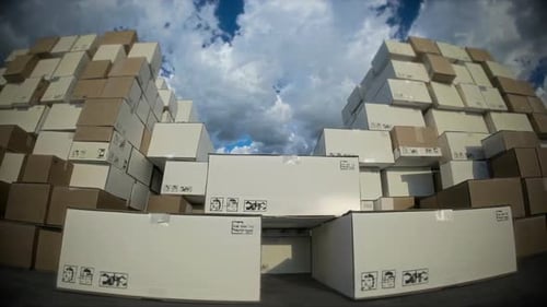 High Stacks of Cardboard Boxes are Seen Under a Vast Cloudy Sky Creating a Striking Image