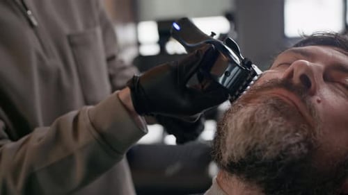 Barber Trimming Mans Beard