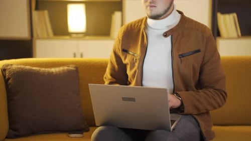Man Working on Laptop on Couch at Home