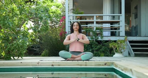 Woman meditating by pool at home, practicing yoga and relaxation outdoors, copy space