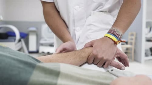 Ärztin, Physiotherapeutin, Ärztin, diagnostiziert Hand wegen rheumatoider Arthritis, älterer Mann, ca.