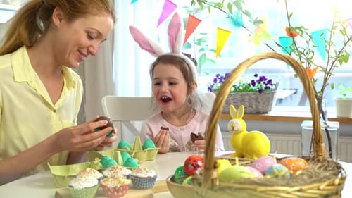 Mother and Daughter Enjoy Chocolate Eggs on Easter
