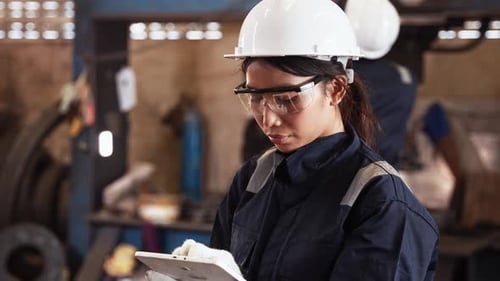 Female industrial engineer using a digital tablet at a factory
