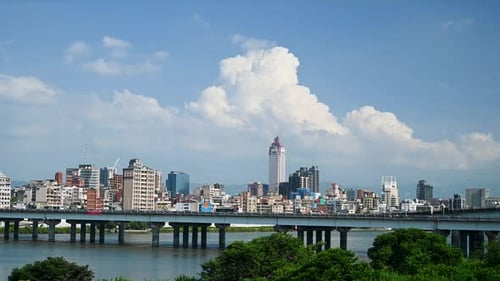 The blue sky and white clouds roll and move. Busy city traffic landscape.