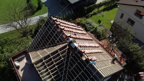 Workers Installing Red Roof Tiles on Building