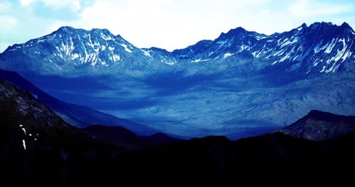 Majestic Mountains Rise Under a Bright Sky with Shining Peaks