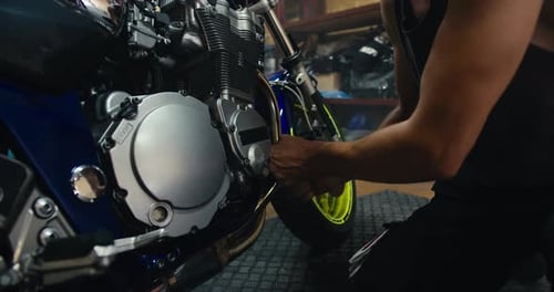 Mechanic Repairing Motorcycle Engine in Shop