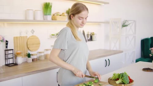 Woman Prepares Vegetables in Bright Kitchen