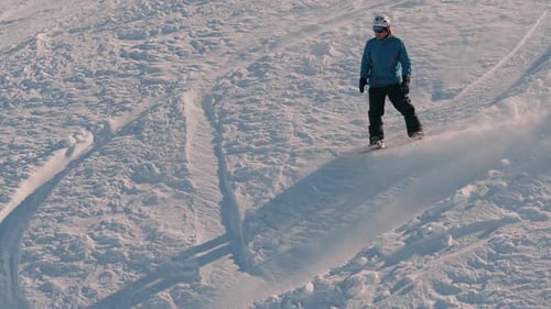 Snowboarder Riding Down a Snowy Mountain Slope – Winter Adventure Scene