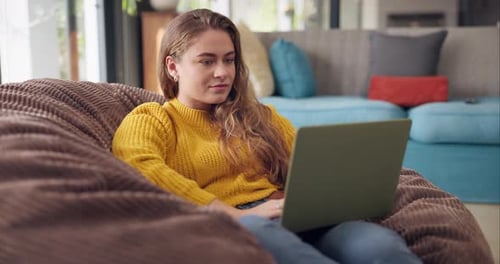 Woman Working on Laptop in Beanbag Chair at Home