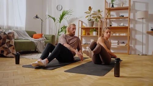 Sportive Couple Sitting on Yoga Mats and Doing Abs Exercise