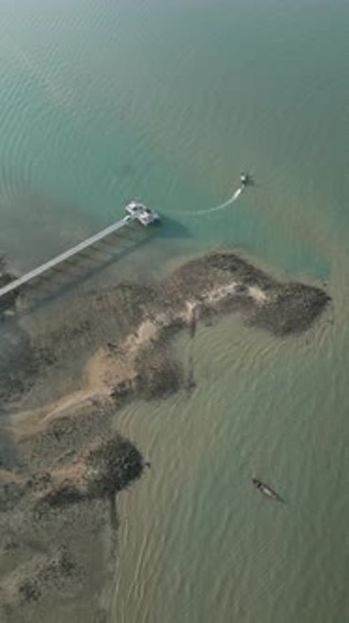 Vertical Video Aerial View of a Tropical Beach Harbor with Sailboats Near the Shore