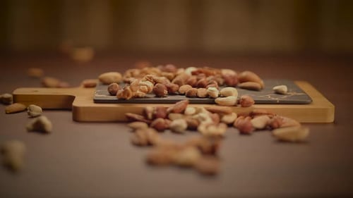 A Variety of Assorted Nuts Displayed Beautifully on a Wooden Board with a Slate Background