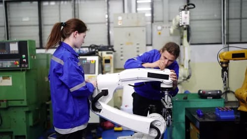 Engenheiros inspecionando e verificando a máquina automatizada de robôs de soldagem de máquinas de armas na fábrica.